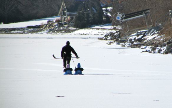 A dad towing his kids in sleds and introducing them to hockey in Minnesota, USA.
