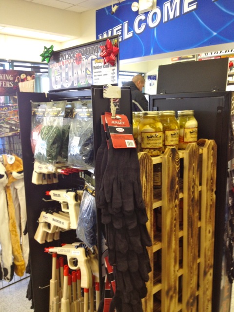 A gun display, gloves and pickled eggs on the side. 